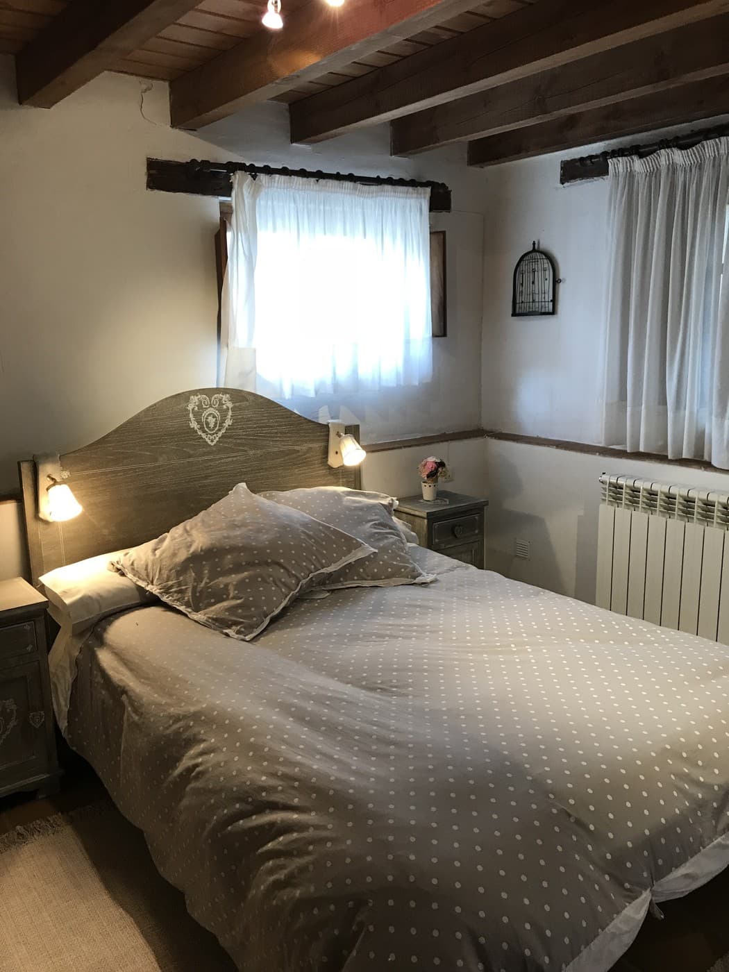 Dormitorio de San Vitores con vigas de madera y luz natural